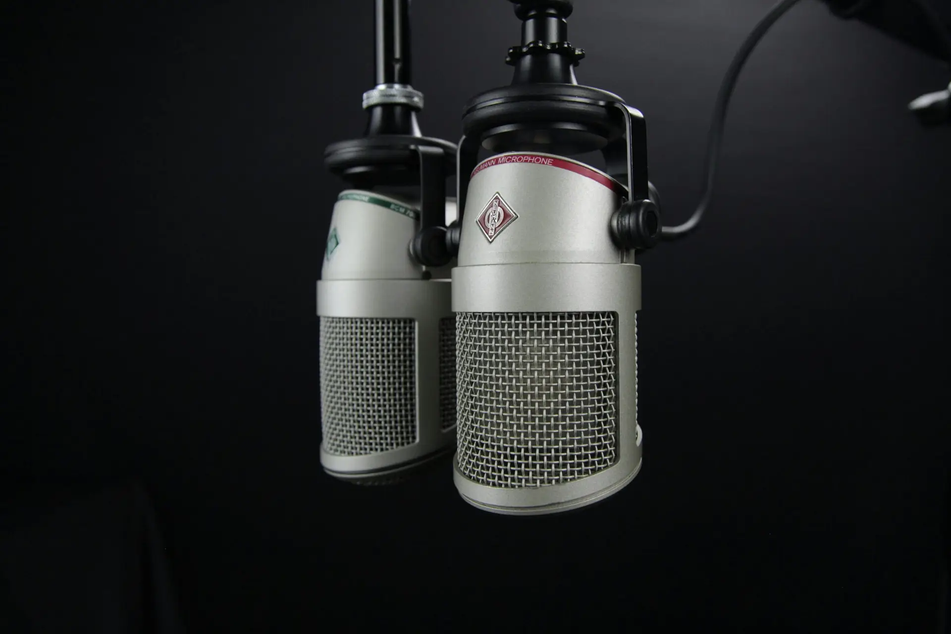 Close-up of two professional microphones in a recording studio, ideal for podcasts and music production.