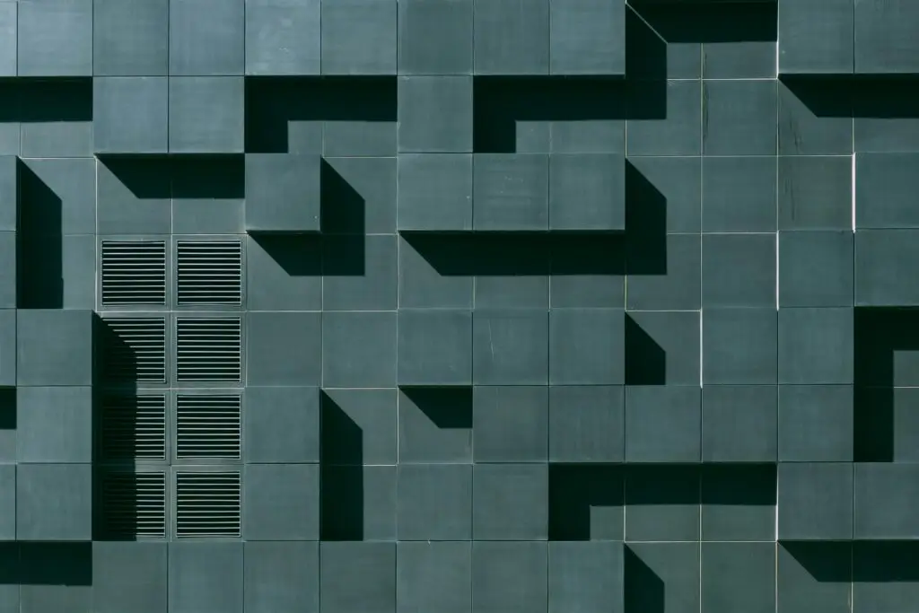 A geometric wall with repeating square patterns and shadows, used to illustrate visual pattern recognition and memory cues.